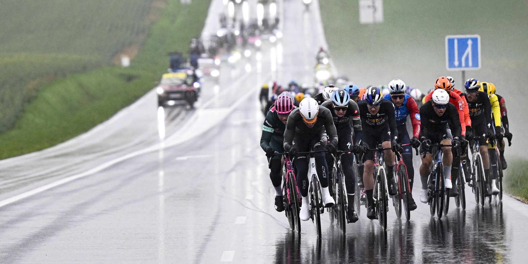 Echelon formation during Paris-Nice cycling race on wet road with peloton racing in rain