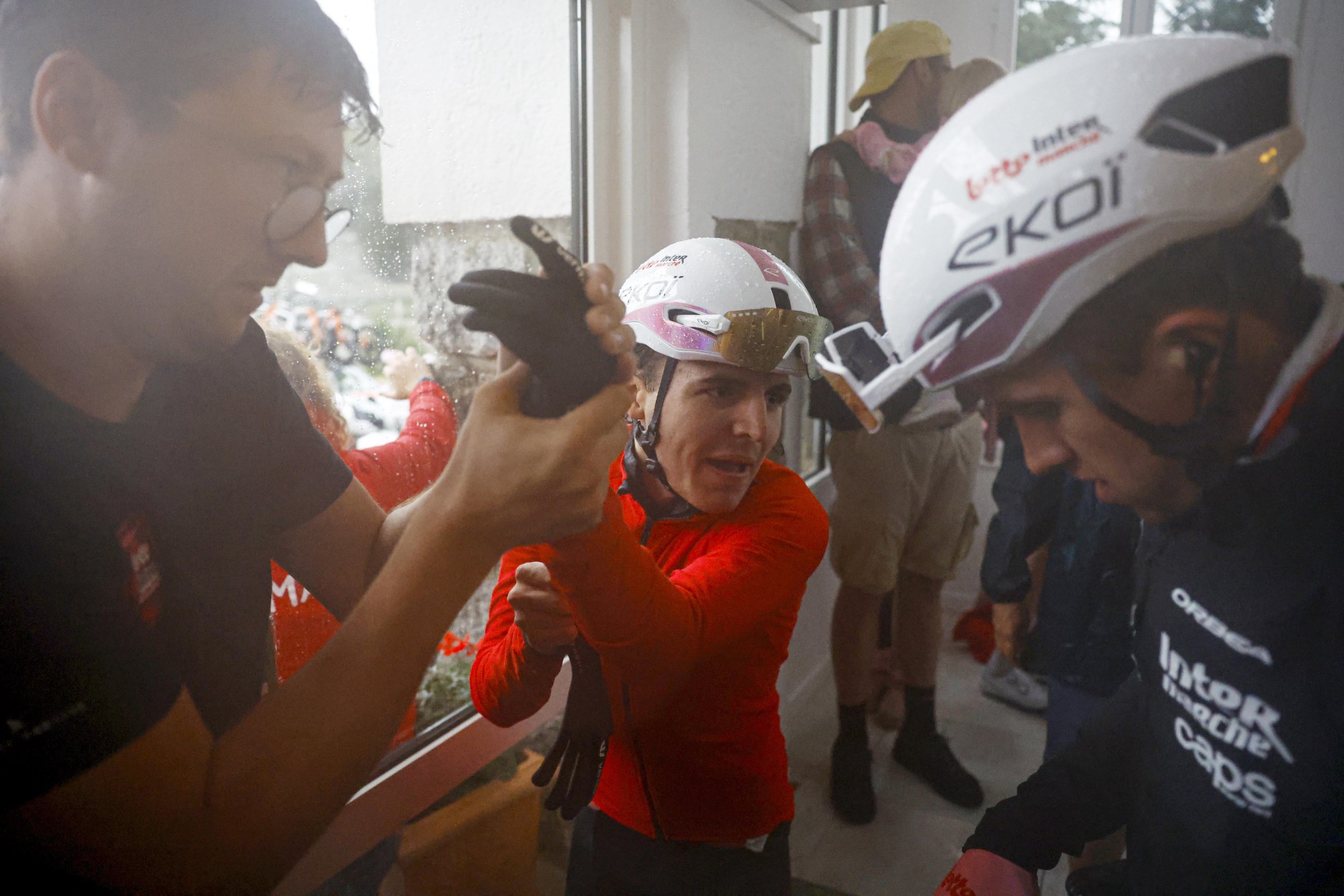 Cyclists spraying water bottles in celebration indoors after Vuelta a Espana stage