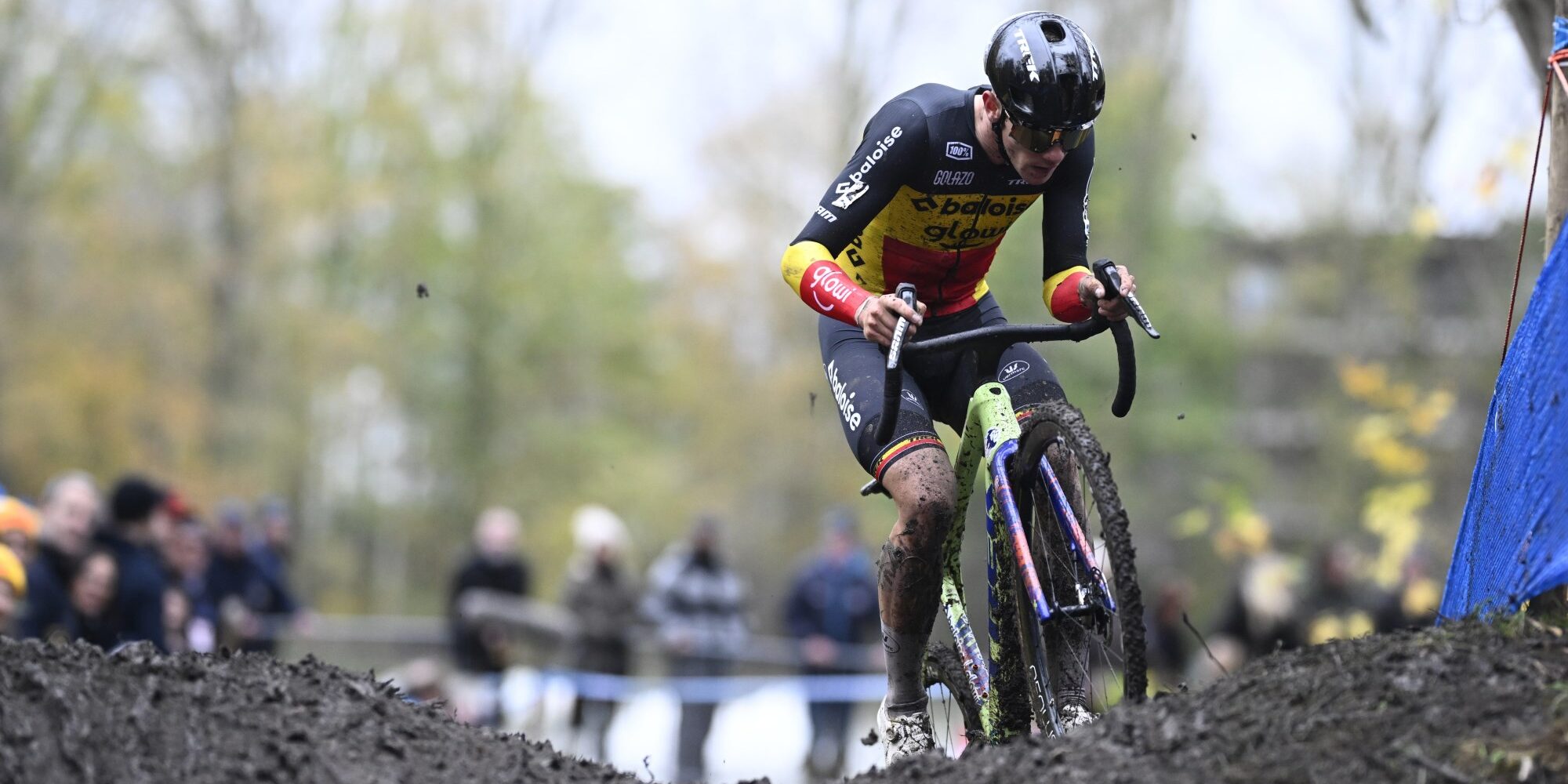 Thibau Nys in Belgian champion jersey navigating muddy cyclocross course at X2O Badkamers Trofee Hamme