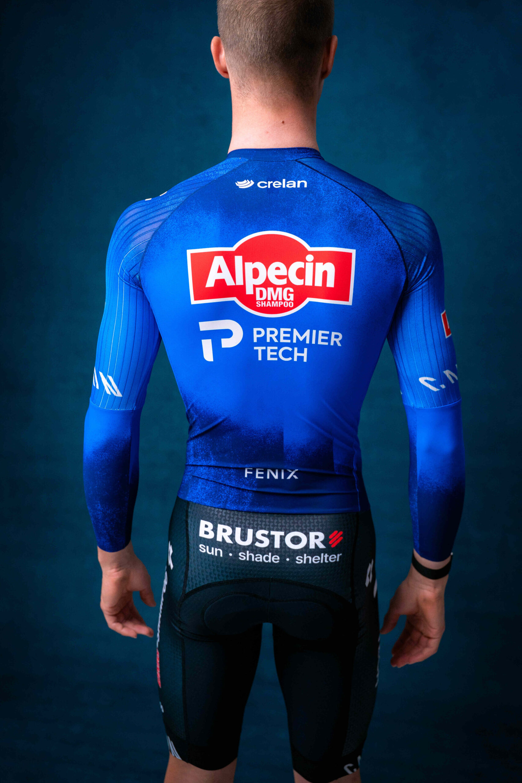 Cyclist in blue Alpecin-Deceuninck jersey from behind in studio portrait