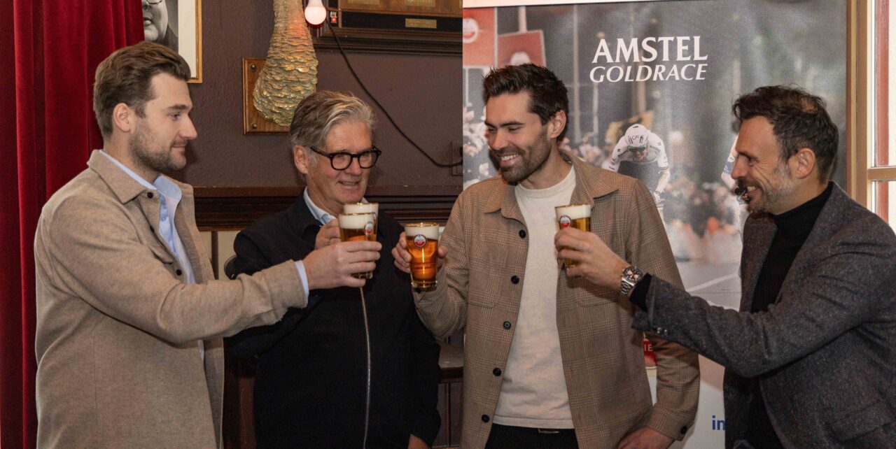 Tom Dumoulin and three men toasting with beer at Amstel Gold Race press conference