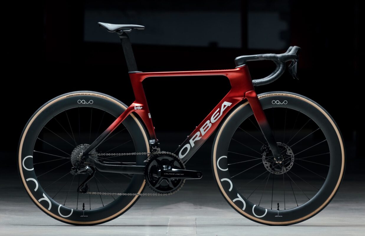 Orbea red aero road bike with deep-section carbon wheels in studio setting